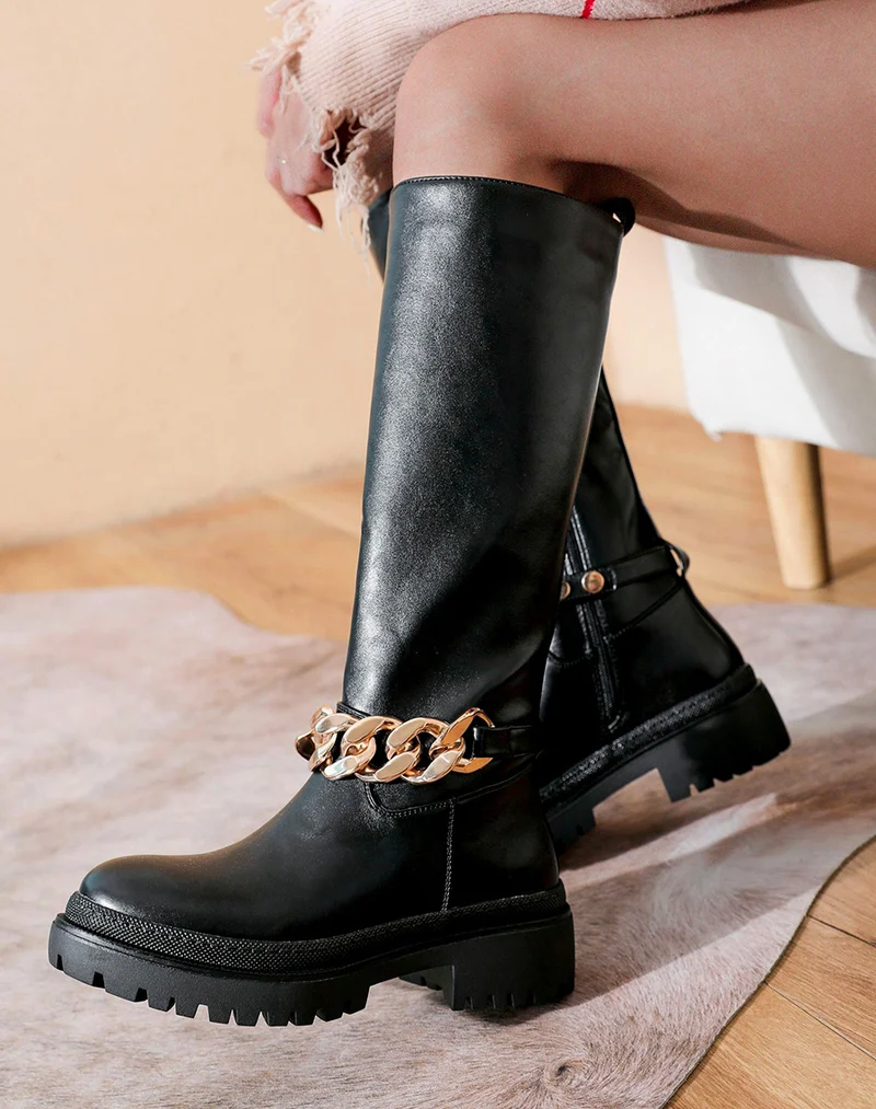Bottes hautes noires ornées d’une chaîne dorée