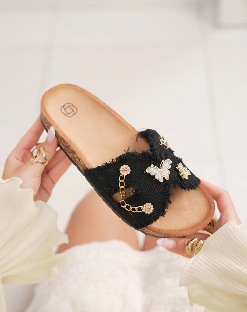 Mules femme noires tendance avec bride croisée effet déchiré et bijoux dorés fantaisie