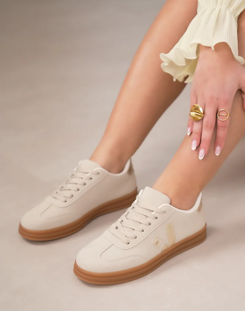 Basket femme beige élégante en suédine avec détails dorés et semelle marron