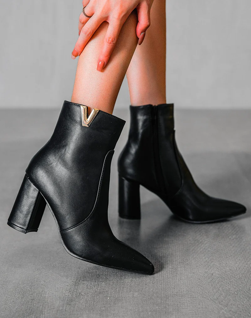 Bottines noires à détail doré en forme de v
