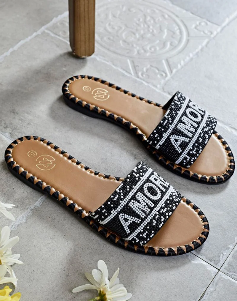 Mules noires à bride avant à inscription perlée