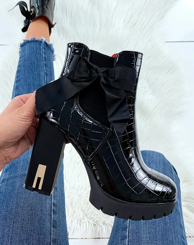 Bottines à talon effet croco verni noir ornées d’un nœud